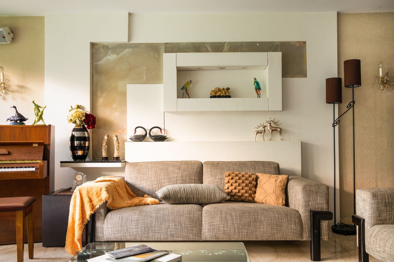 Cozy living room featuring a sofa, decorative items, and a piano, perfect for a stylish home interior.